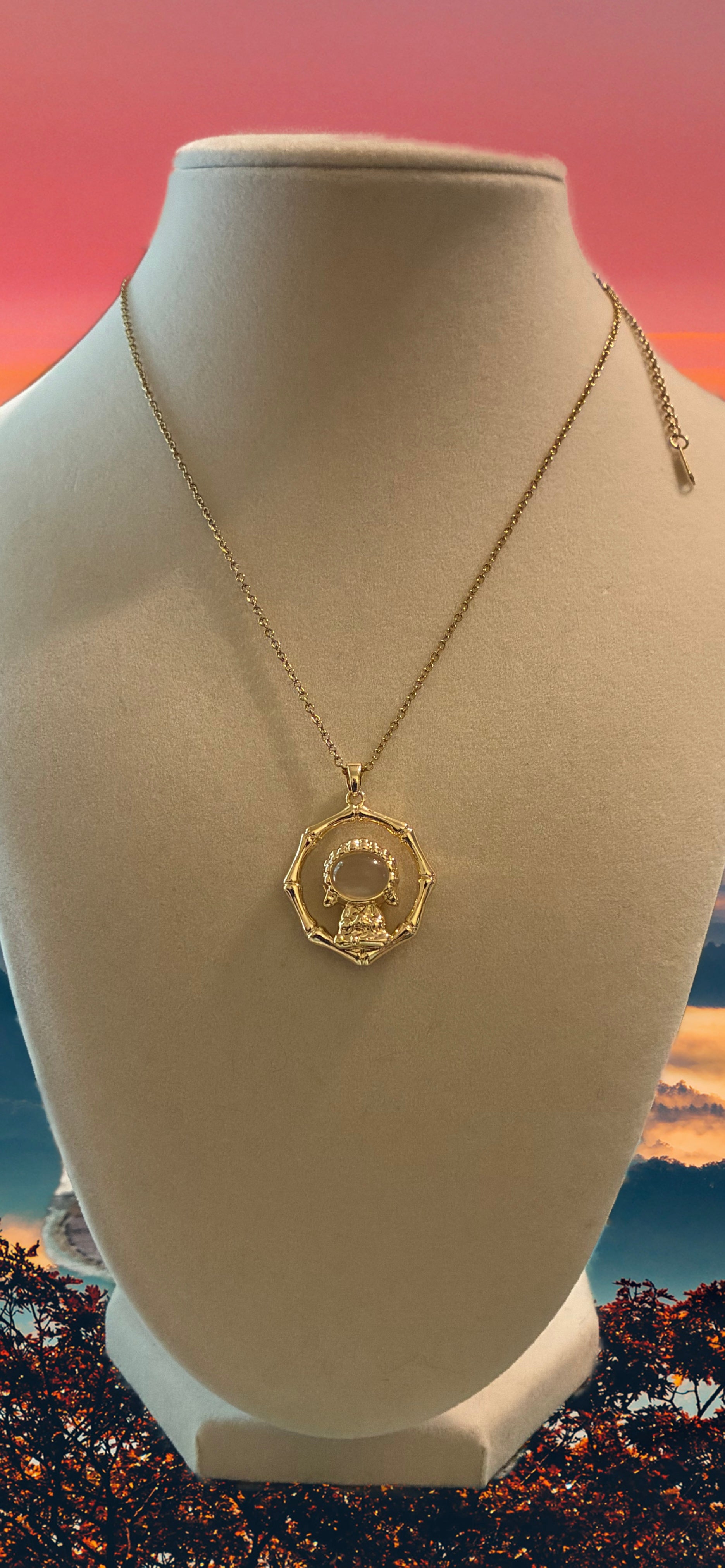 Stainless steel, gold plated Buddha with white jade stone surrounded by ￼bamboo ￼