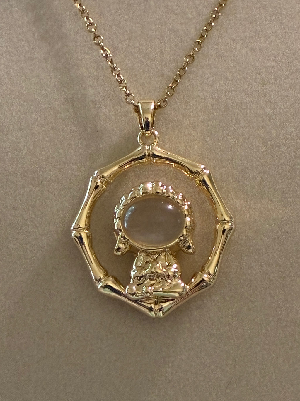 Stainless steel, gold plated Buddha with white jade stone surrounded by ￼bamboo ￼