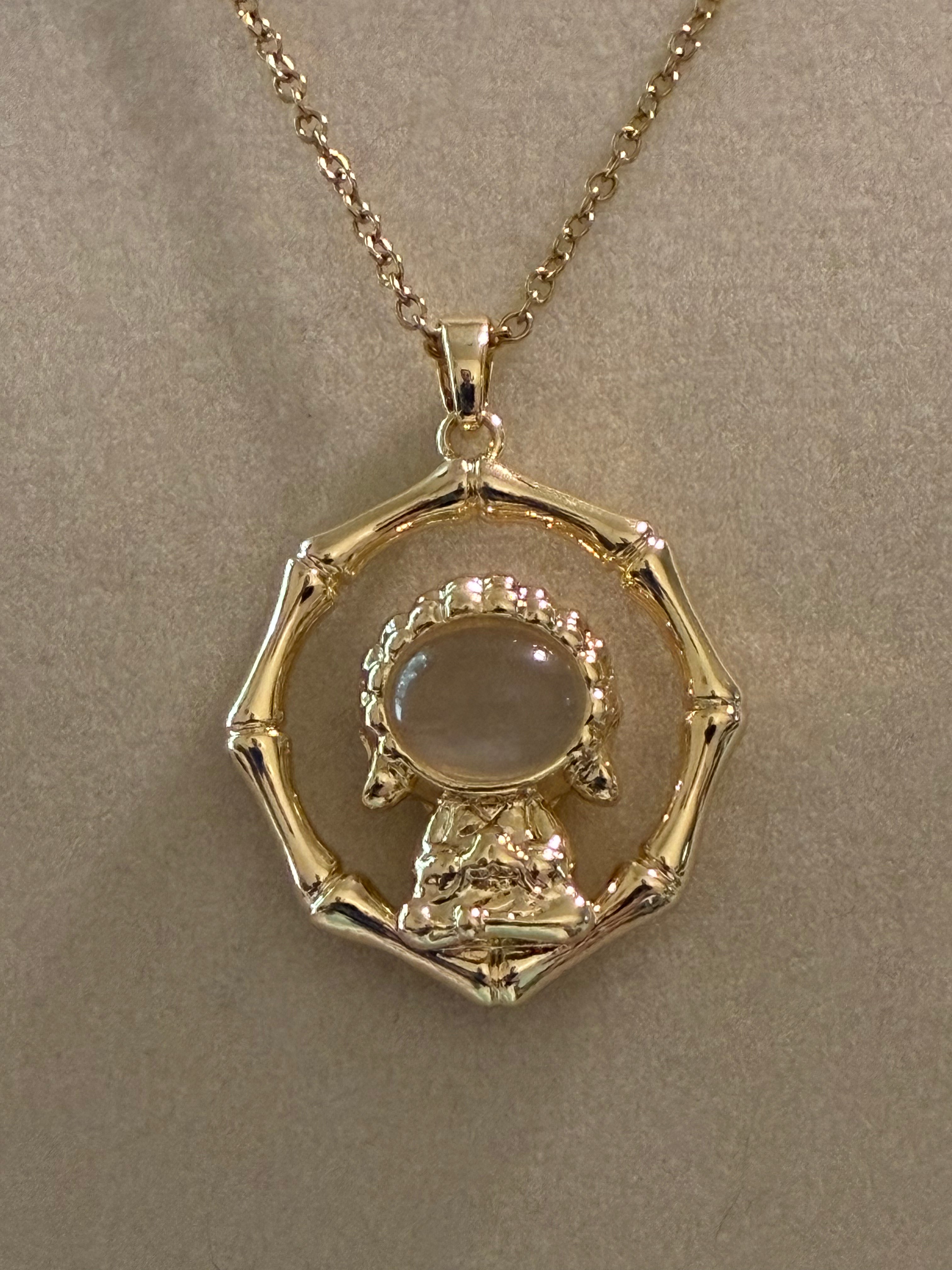 Stainless steel, gold plated Buddha with white jade stone surrounded by ￼bamboo ￼