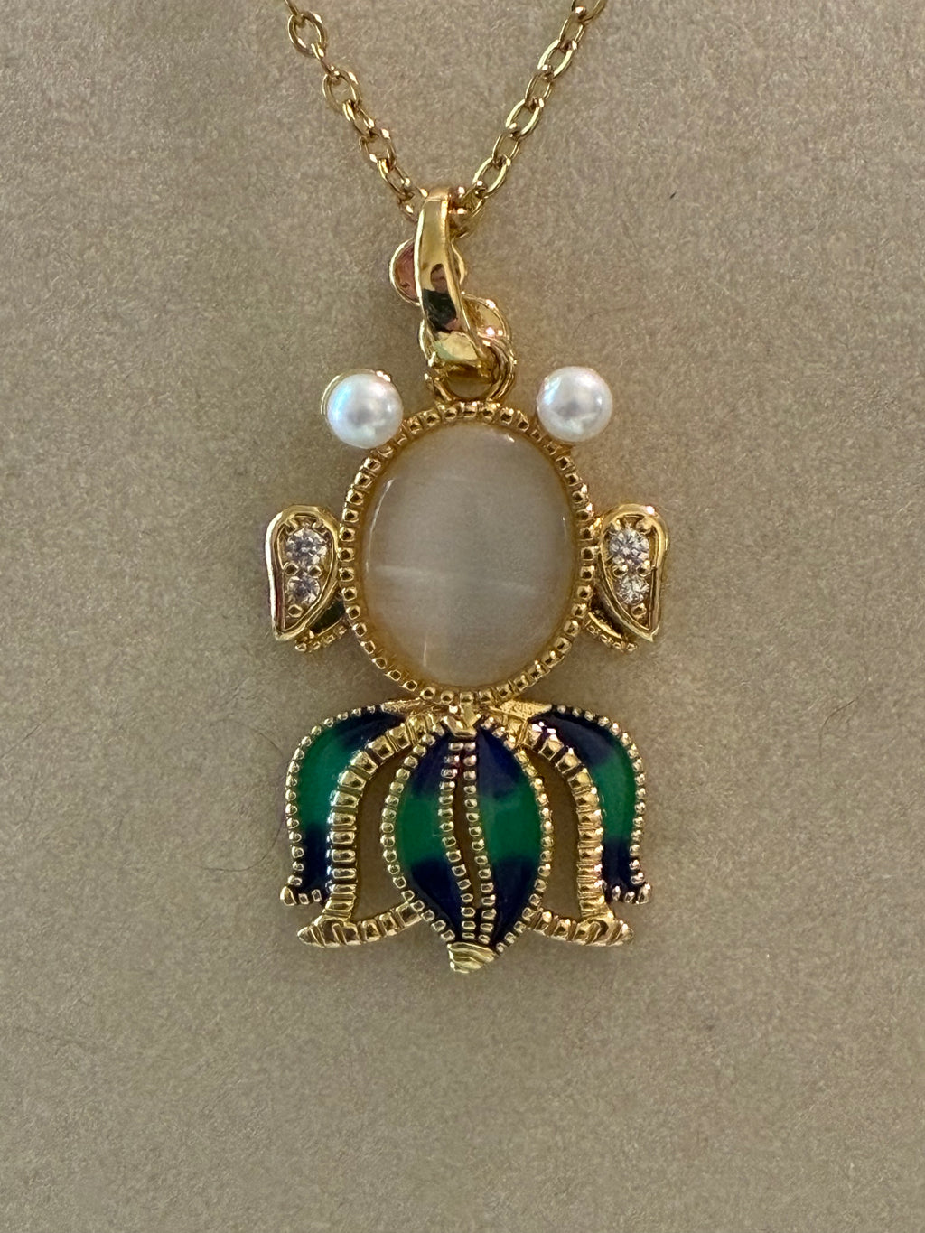 Stainless steel, gold plated, fish with moonstone, pearl eyes and rhinestones