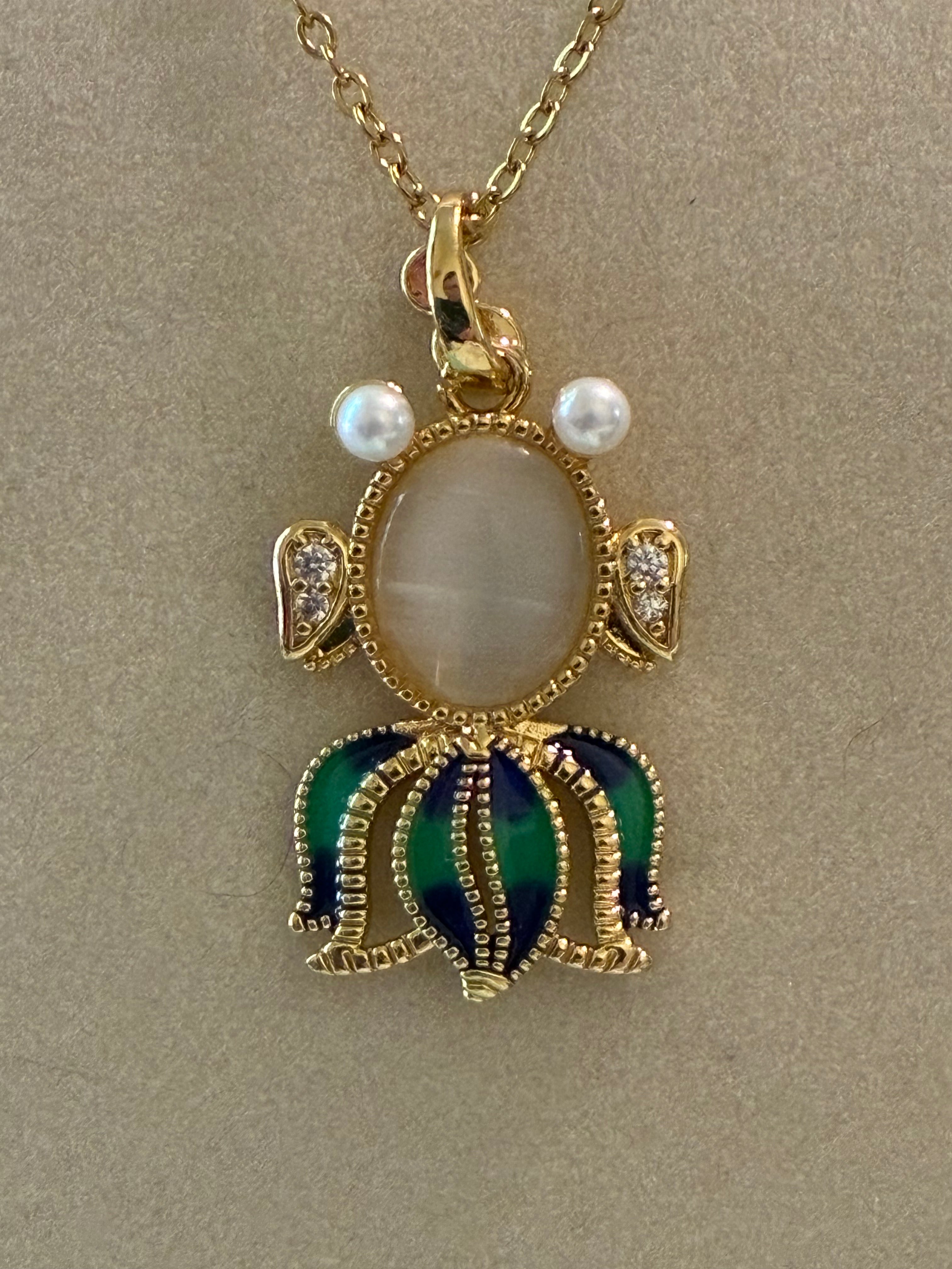 Stainless steel, gold plated, fish with moonstone, pearl eyes and rhinestones